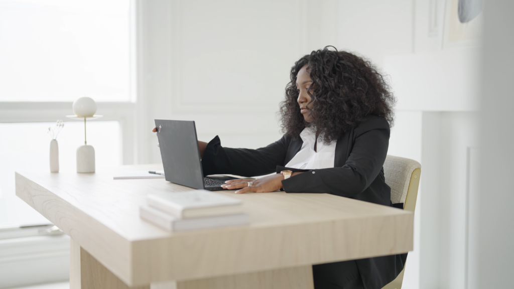 Graduate from Ivey Business School MBA program working at a desk on a laptop.